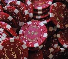 a pile of red and white poker chips with the number fifty on them in gold lettering