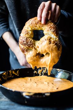 a person dipping cheese on top of a bagel in a skillet with the words seven easy dinners