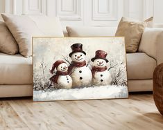 three snowmen are standing in front of a painting