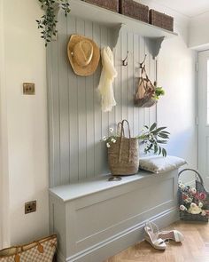 there is a bench with baskets and hats on the wall next to it, along with other purses