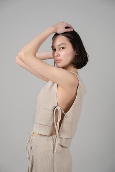 Looking for a genuine super soft and everyday top? Designed in a light silhouette, sleeveless Mia Side Ties Top can be worn with ease all summer long and compliments most body types with adjustable side-ties. - 100% Turkish double layered gauze cotton - Side slits tied with adjustable side-ties.- Crop top finish at waist Summer Loungewear Tops With Tie Waist, Beige Tie Back Tops For The Beach, Beige Tie Back Tops For Beach, Beige Tank Top For Loungewear, Sleeveless Drawstring Tops For Loungewear, Summer Loungewear Top With Tie Back, Summer Style Sleeveless Crop Top For Everyday, Summer Sleeveless Crop Top For Everyday, Summer Tie-back Top For Loungewear