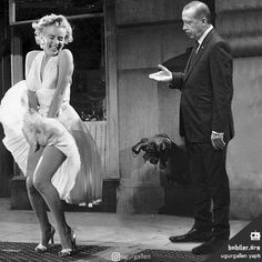 an old photo of a man and a woman dancing on the street in front of a building