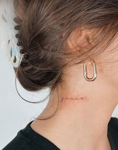 a woman with a small tattoo on her neck