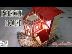 a small wooden house made out of wood planks with the words popsicle house above it