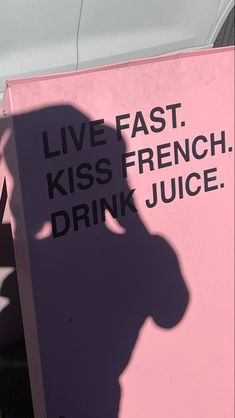 a pink sign with the words live fast kiss french drink juice on it's side