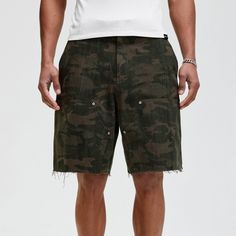 The Frayed Double-Knee Camo Cargo Shorts masterfully blend military elements with street style. These slightly oversized shorts feature an all-over camouflage print and a durable double-knee design for added toughness. The frayed hem adds an edgy touch, while the back pocket is adorned with a metal logo badge for a distinctive look. Crafted from premium 100% cotton fabric (370g/m²), these shorts ensure both comfort and durability, making them perfect for any urban adventure. All-over camouflage Summer Combat Cotton Bottoms, Military Camouflage Cotton Shorts, Camouflage Military Cotton Shorts, Utility Camouflage Cotton Cargo Shorts, Camouflage Utility Shorts, Military Style Camouflage Cotton Cargo Shorts, Relaxed Fit Khaki Cargo Shorts For Streetwear, Military Style Camouflage Cargo Shorts, Khaki Cargo Shorts With Built-in Shorts For Streetwear