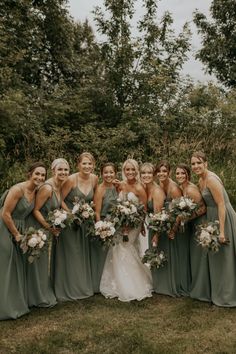 a group of women standing next to each other on top of a lush green field