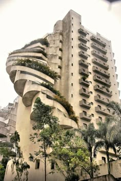 a tall building with many balconies and plants growing on it's side