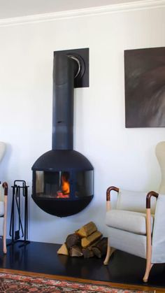 a living room with two chairs and a fire place in the middle of the room