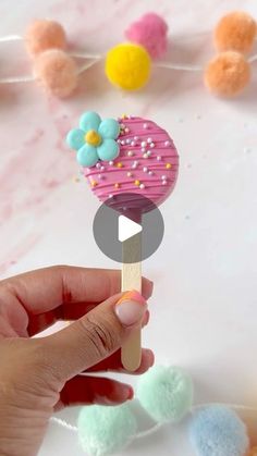 a person holding a popsicle with sprinkles on it