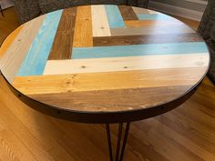 a wooden table sitting on top of a hard wood floor next to a gray couch