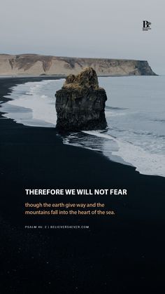 there is a black sand beach with waves coming in to the shore and a rock sticking out of the water