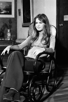 a woman sitting in a rocking chair with her legs crossed