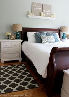 a bedroom with a bed, nightstands and two pictures on the wall above it