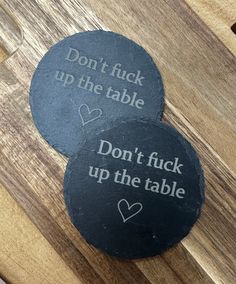 two slate coasters with words on them that say don't fock up the table