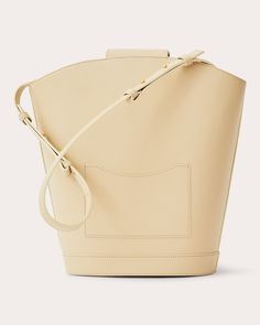 A nod to photographer Vivian Maier, this Objets Daso bag juxtaposes expressive shapes with refined details to create an elegant bucket design. The calfskin leather silhouette features polished goldtone hardware and a signature push-lock closure for elevated appeal. Signature push-lock closure Adjustable shoulder strap Goldtone hardware One interior and one exterior pocket Outer: 100% calfskin leather Lining: 100% lambskin leather Store in dust bag Made in Italy Measurements Width: 8.26in Height: 12.4in Depth: 5.9in | Objets Daso Women's Vivian Bucket Bag in Ivory | Leather Modern Structured Bucket Bag With Detachable Handle, Designer Cream Bucket Bag, Designer Cream Bucket Bag With Detachable Handle, Modern Beige Bucket Bag With Detachable Handle, Modern Bucket Bags With Gold-tone Hardware, Cream Rectangular Bucket Bag For Evening, Modern Structured Bucket Bag For Formal Occasions, Elegant Cream Bucket-shape Shoulder Bag, Elegant Cream Bucket Shape Shoulder Bag