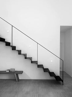 a black and white photo of a stair case in a room with wood flooring