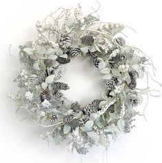 a wreath with pine cones and white flowers