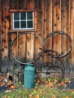 a metal sculpture sitting in front of a wooden building