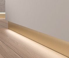 an empty room with white walls and wood flooring is lit by the light from below