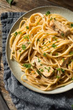 a plate of pasta with chicken and parsley