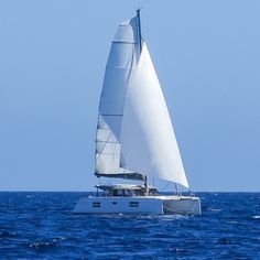 a sailboat sailing in the ocean on a sunny day with blue sky and water