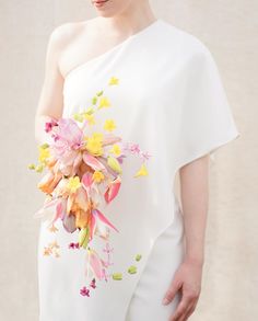 a woman wearing a white dress holding a bouquet of flowers