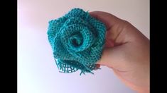 a hand holding a green crocheted flower