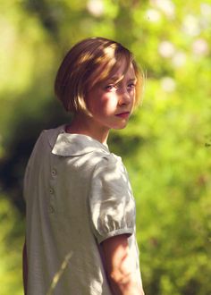 a young boy holding a white frisbee in his hand and looking at the camera