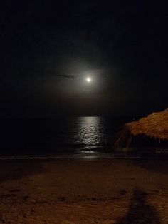 the moon is shining over the ocean at night