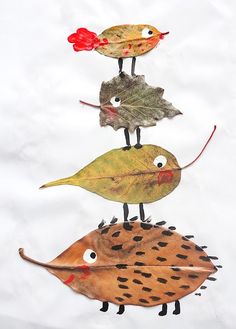 three birds are sitting on top of each other in the shape of leaves and acorns