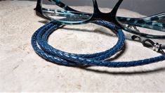 "This iris blue braided leather eyeglass chain makes it easy to keep track of your reading glasses. It has been meticulously handcrafted in minute detail and is made to last through countless uses. Unlike the cheap plastic eyeglass holders available in stores, this braided leather eyeglass chain is high quality and makes for an attractive accessory whether at home or the office. The unisex design makes it a functional accessory for both men and women. It also makes an excellent gift for the prof Eyeglasses Holder, Glasses Chains, String Bag, Eyeglass Chain, Eyeglass Holder, Glasses Chain, Functional Accessories, Eye Wear Glasses, Eyeglasses For Women