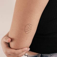 a woman's arm with a small tattoo on the left side of her arm