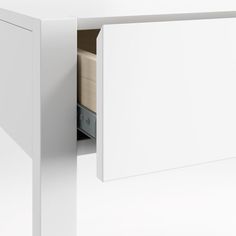 a close up of a white cabinet with drawers in the bottom section and an open drawer underneath it