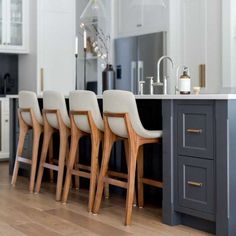 the chairs are lined up in front of the kitchen island