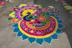 a colorful rangdi design on the ground with flowers and leaves painted on to it