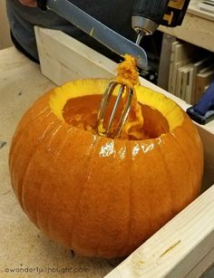 a pumpkin being carved with a power tool