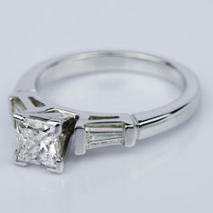 a diamond ring with three baguets on the side