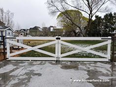 a white gate is open on a rainy day