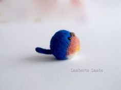 a small blue bird sitting on top of a white table