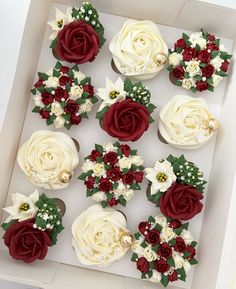 twelve cupcakes in a box decorated with red and white flowers