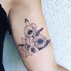 a woman's arm with flowers on it and an arrow in the middle,