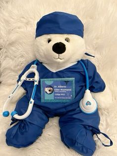 a teddy bear dressed in blue with a stethoscope on it's chest