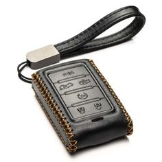 a car keychain attached to a black leather case with gold chain and padlocks