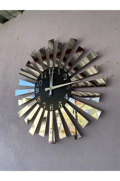 a clock that is on the side of a wall with mirrors in it's center