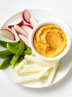 a white plate topped with vegetables and dip