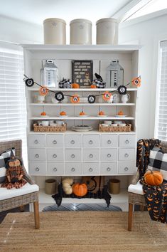 a living room filled with furniture and lots of pumpkins on top of the shelves