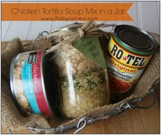 a basket filled with lots of food on top of a wooden table next to a jar