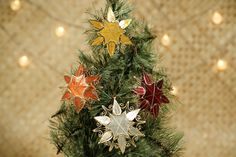 a small christmas tree decorated with leaves and ornaments