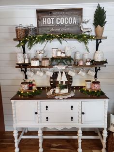 a white buffet table topped with lots of desserts and christmas decorations on top of it